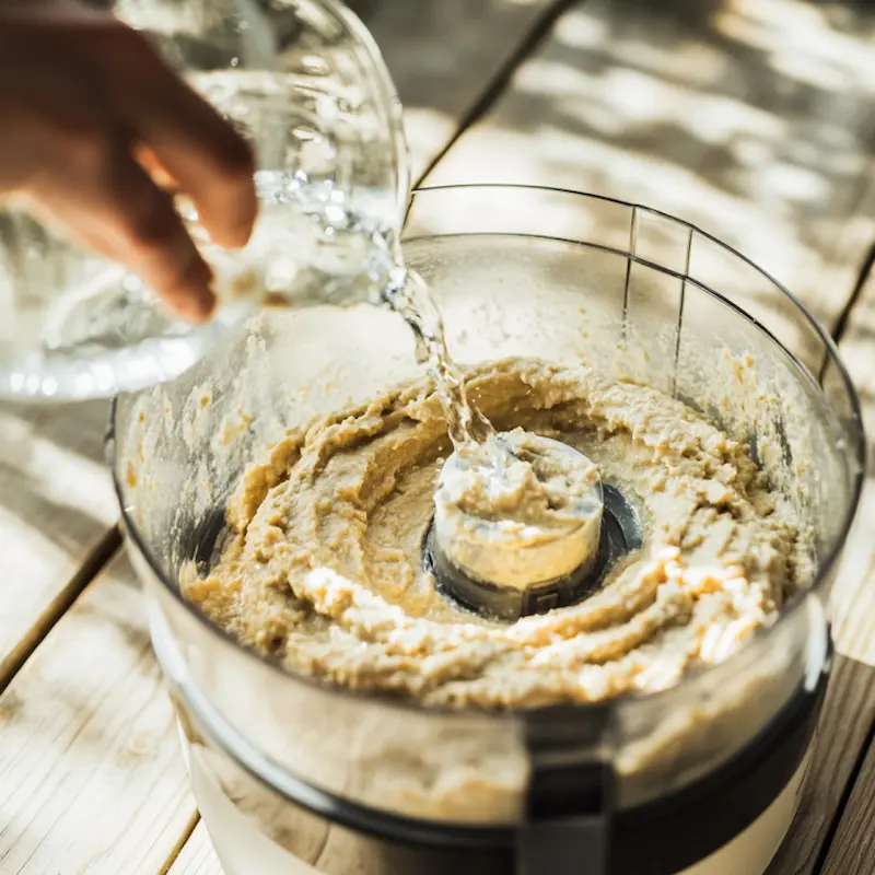 Mixeur avec houmous en préparation sur plan de travail